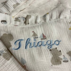 Arrullo artesanal para bebé personalizado con nombre Leire bordado a mano, hecho en Don Botón, tonos rosa empolvado y blanco.